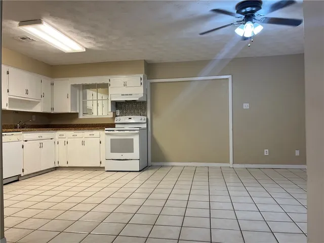 a kitchen with a stove a refrigerator and cabinets