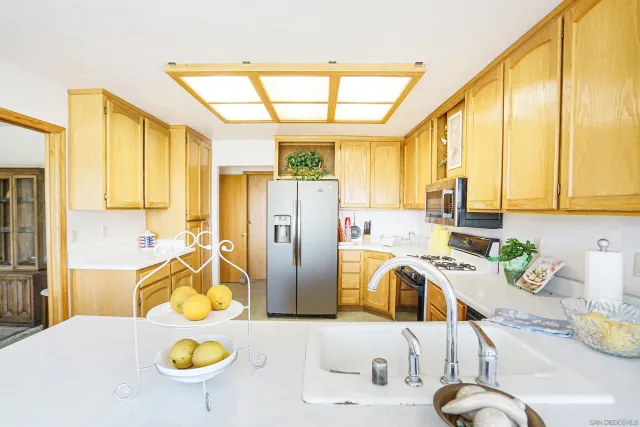 a kitchen with stainless steel appliances granite countertop a sink and a window