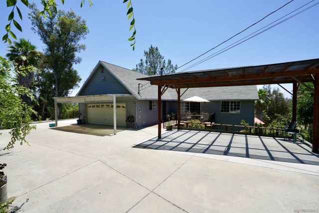 a view of a patio with a table and chairs under an umbrella with a fire pit