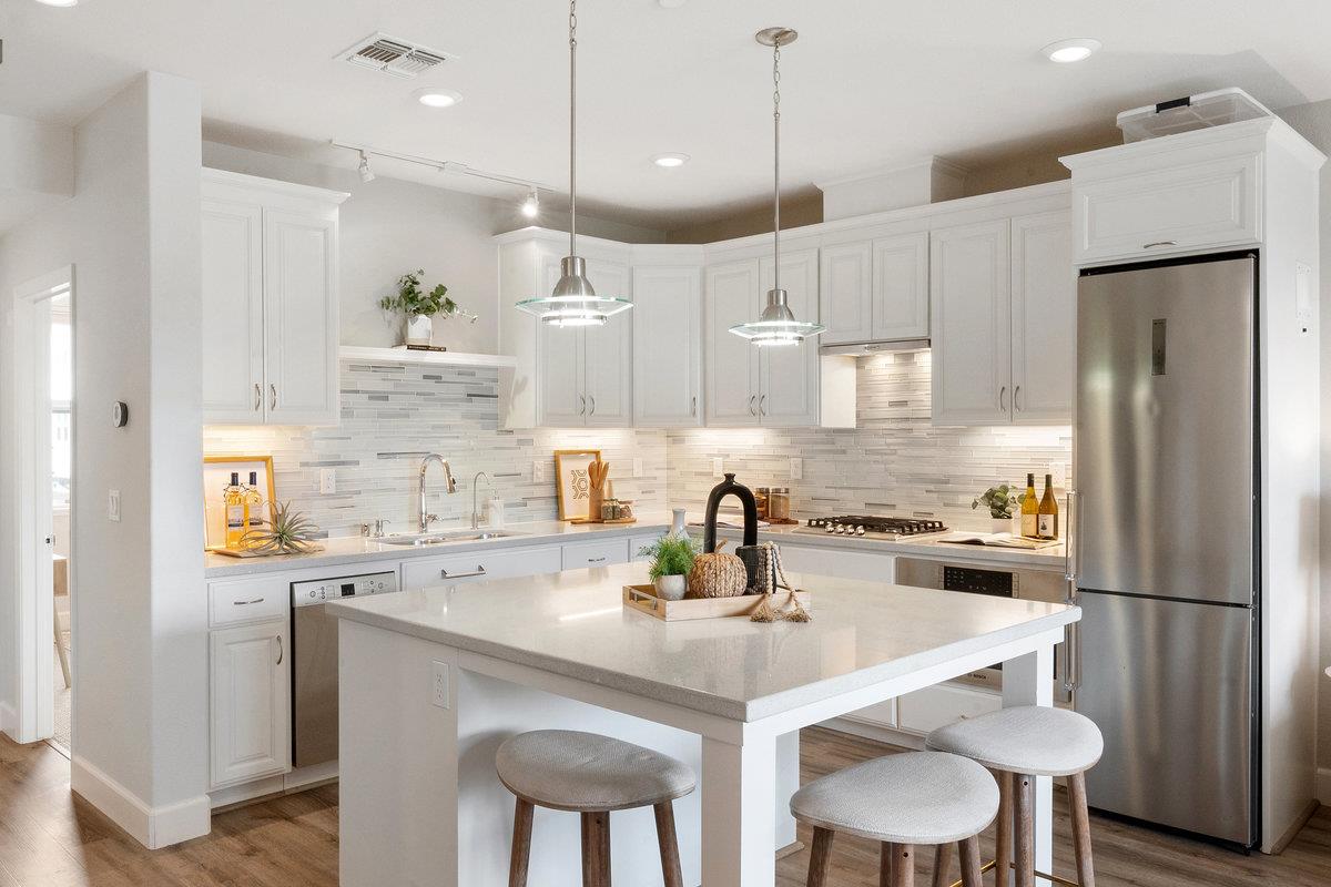 133 Stevenson Boulevard Fremont, CA 94539 - Photo 12 of 36 a kitchen with a sink a refrigerator and chairs