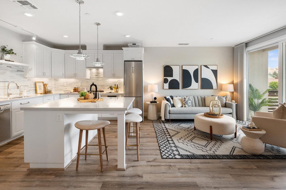 133 Stevenson Boulevard Fremont, CA 94539 - Photo 2 of 36 a kitchen with a dining table chairs sink and white cabinets with wooden floor
