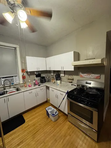 a kitchen with a stove cabinets and wooden floor