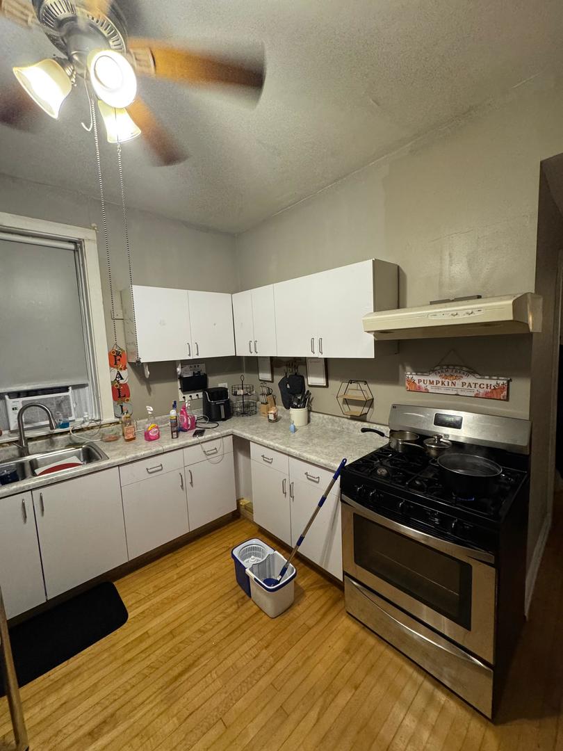 2344 South 58th Avenue, Unit 2 Cicero, IL 60804 - Photo 3 of 11 a kitchen with a stove cabinets and wooden floor