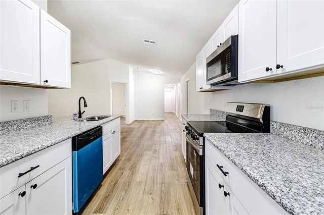 a kitchen with stainless steel appliances granite countertop a sink stove and microwave