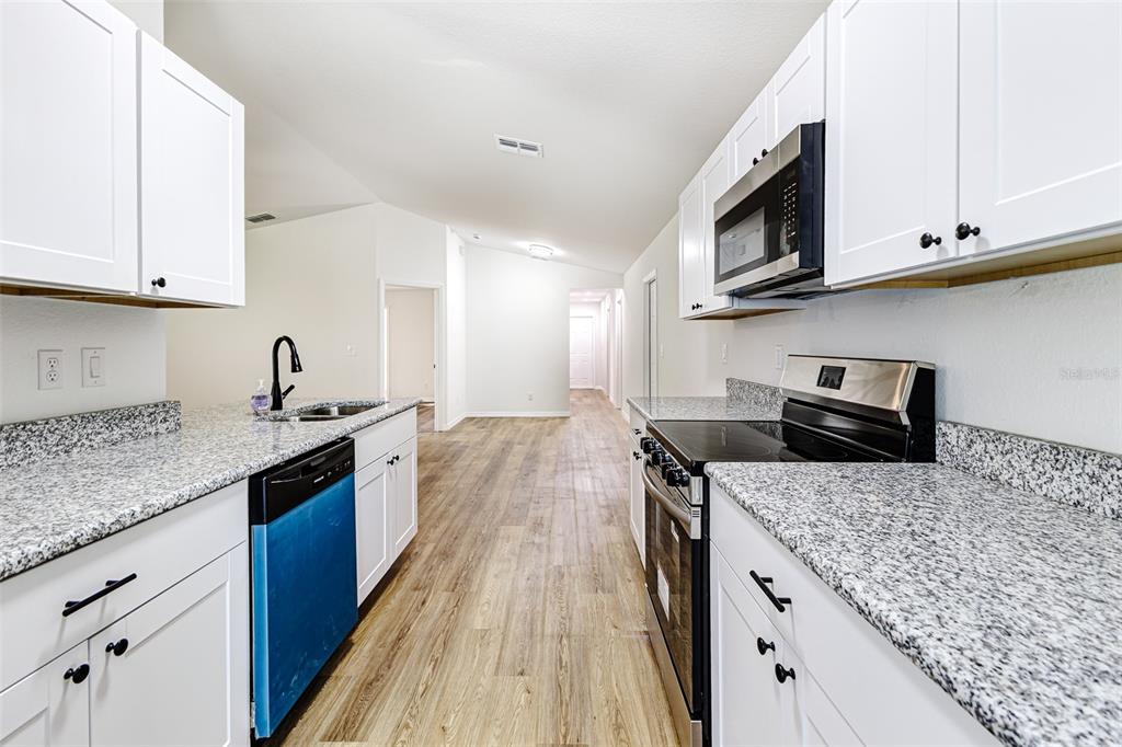 2728 Golfview Street Lakeland, FL 33801 - Photo 11 of 25 a kitchen with stainless steel appliances granite countertop a sink stove and microwave