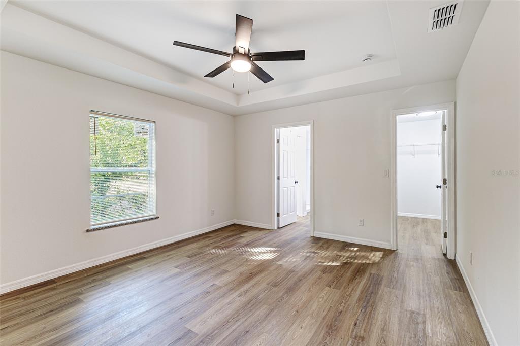 2728 Golfview Street Lakeland, FL 33801 - Photo 12 of 25 an empty room with wooden floor ceiling fan and windows