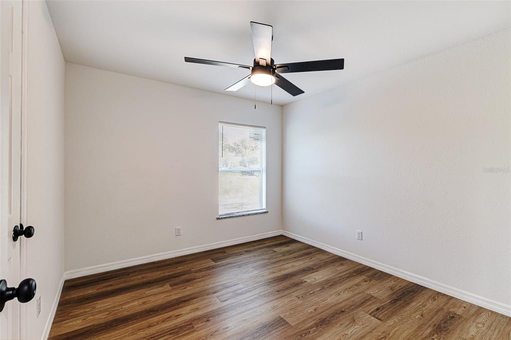 2728 Golfview Street Lakeland, FL 33801 - Photo 17 of 25 an empty room with wooden floor ceiling fan and windows