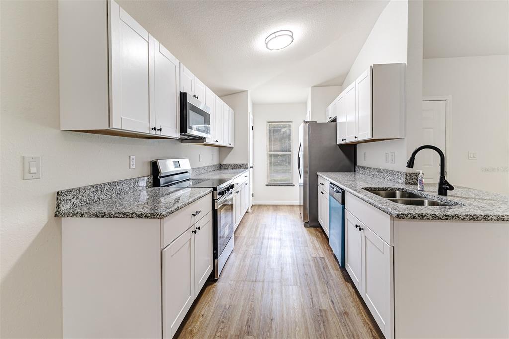 2728 Golfview Street Lakeland, FL 33801 - Photo 8 of 25 a kitchen with stainless steel appliances granite countertop a sink stove and refrigerator