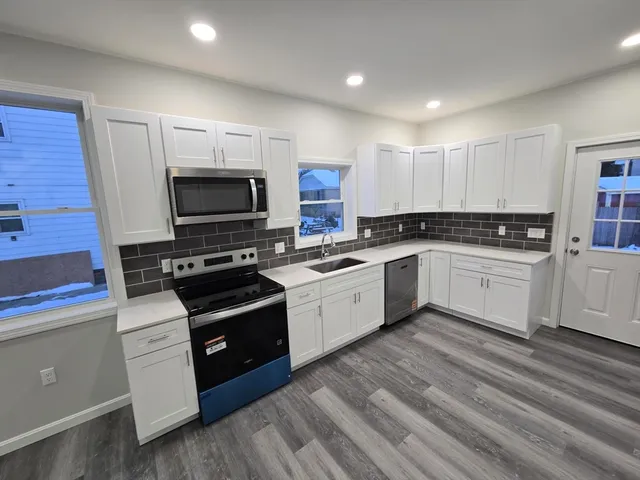 a kitchen with a stove a sink and a microwave