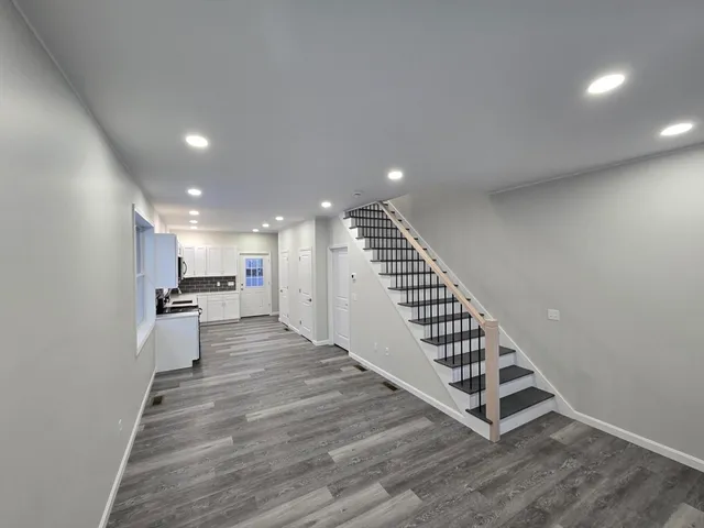 a view of a hallway with wooden floor and staircase