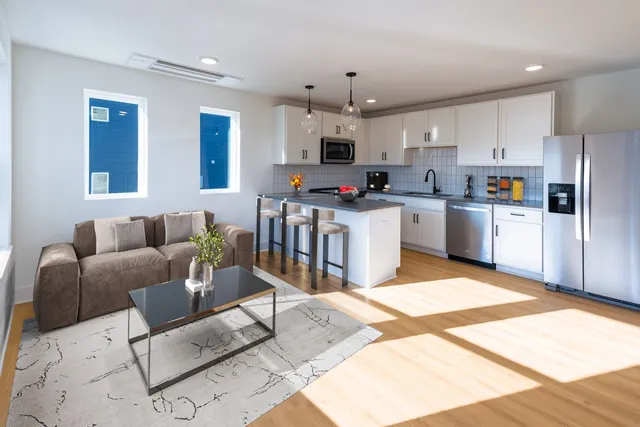 a kitchen with stainless steel appliances kitchen island granite countertop a refrigerator and a stove top oven