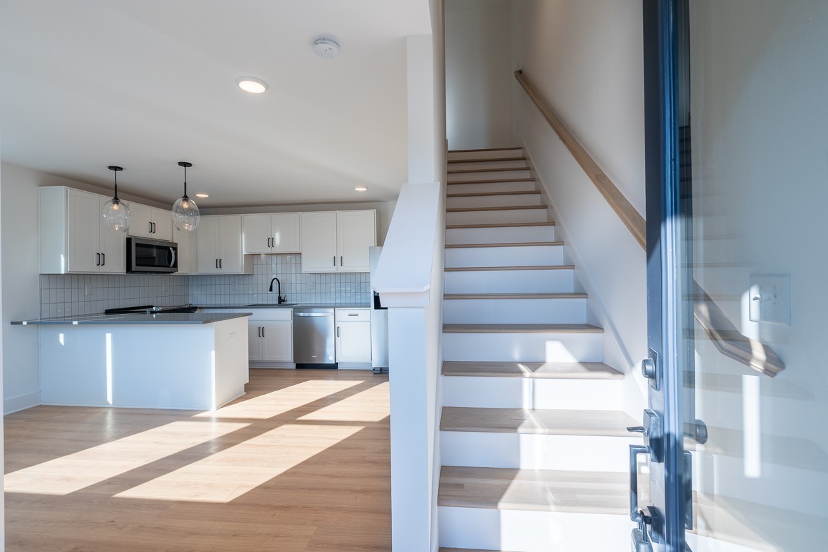 102 Duke Street, Unit 8 Nashville, TN 37207 - Photo 3 of 29 a kitchen with stainless steel appliances kitchen island granite countertop a refrigerator a sink and white cabinets