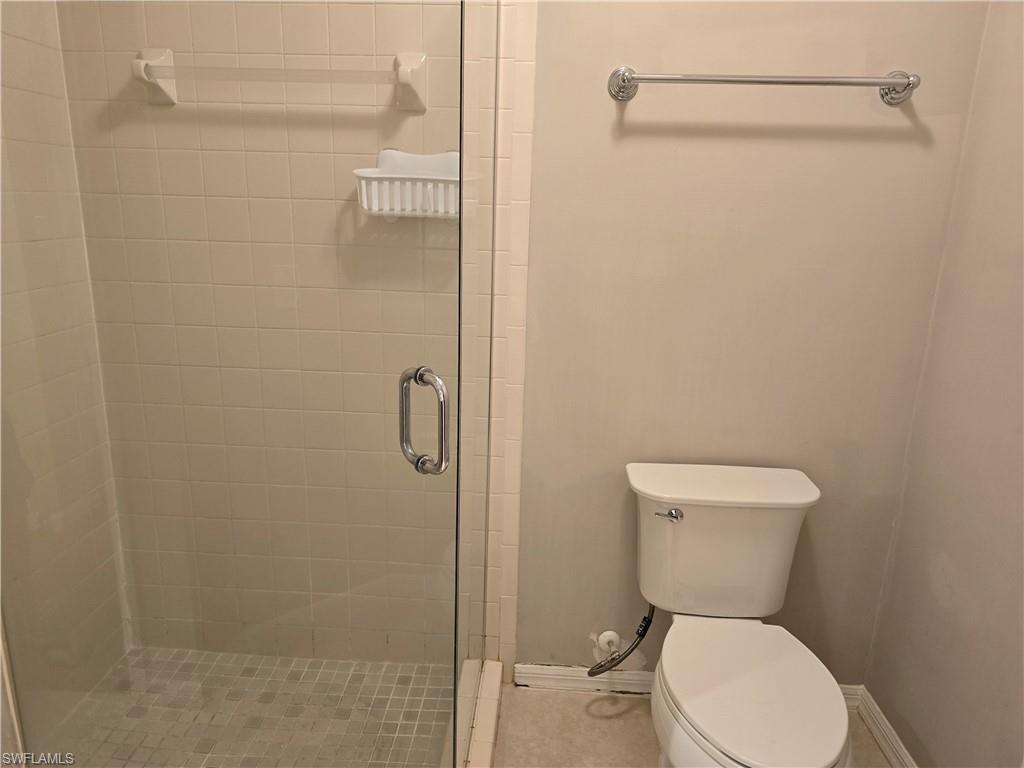 605 Squire Circle, Unit 203 Naples, FL 34104 - Photo 17 of 36 a white toilet sitting next to a bathroom sink