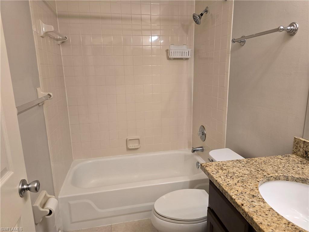 605 Squire Circle, Unit 203 Naples, FL 34104 - Photo 19 of 36 a bathroom with a granite countertop bathtub shower sink vanity and toilet