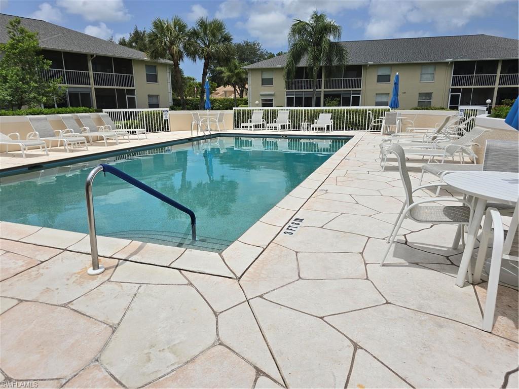 605 Squire Circle, Unit 203 Naples, FL 34104 - Photo 25 of 36 a view of house with swimming pool and outdoor seating