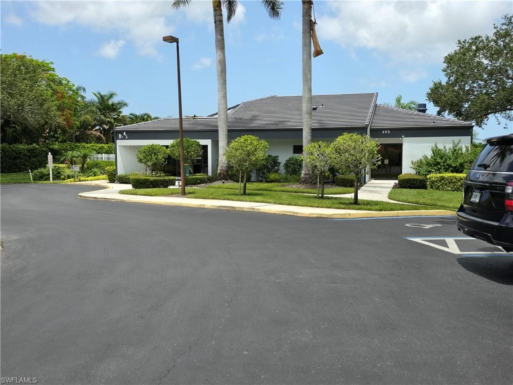 605 Squire Circle, Unit 203 Naples, FL 34104 - Photo 30 of 36 a view of a house with a yard and table and chairs