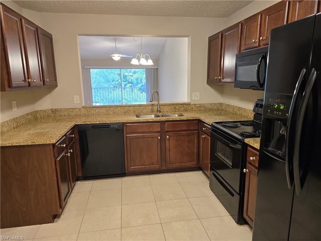 605 Squire Circle, Unit 203 Naples, FL 34104 - Photo 7 of 36 a kitchen with stainless steel appliances granite countertop a sink stove and refrigerator