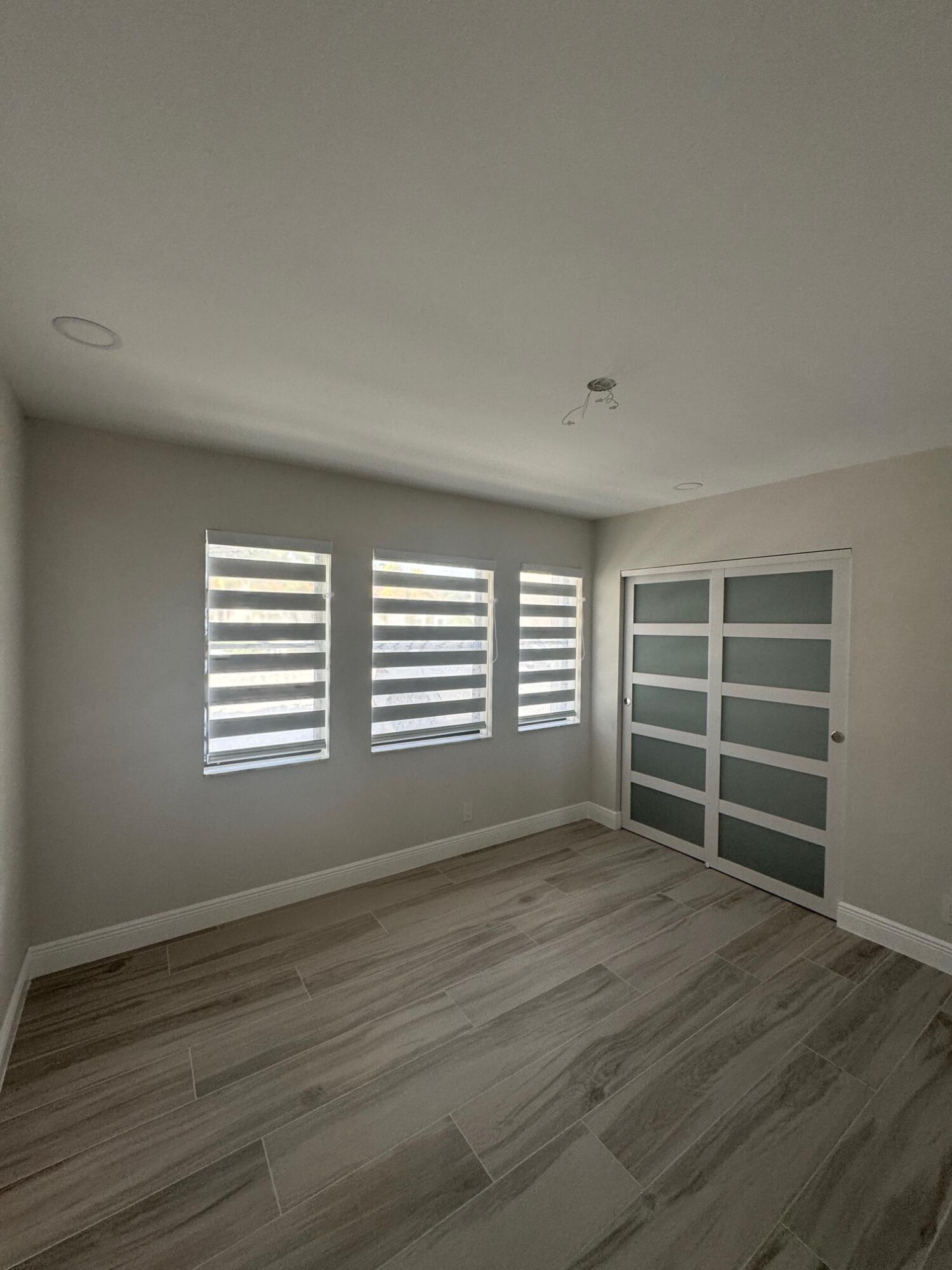 8711 Eagle Run Drive Boca Raton, FL 33434 - Photo 10 of 17 a view of empty room with wooden floor and fan