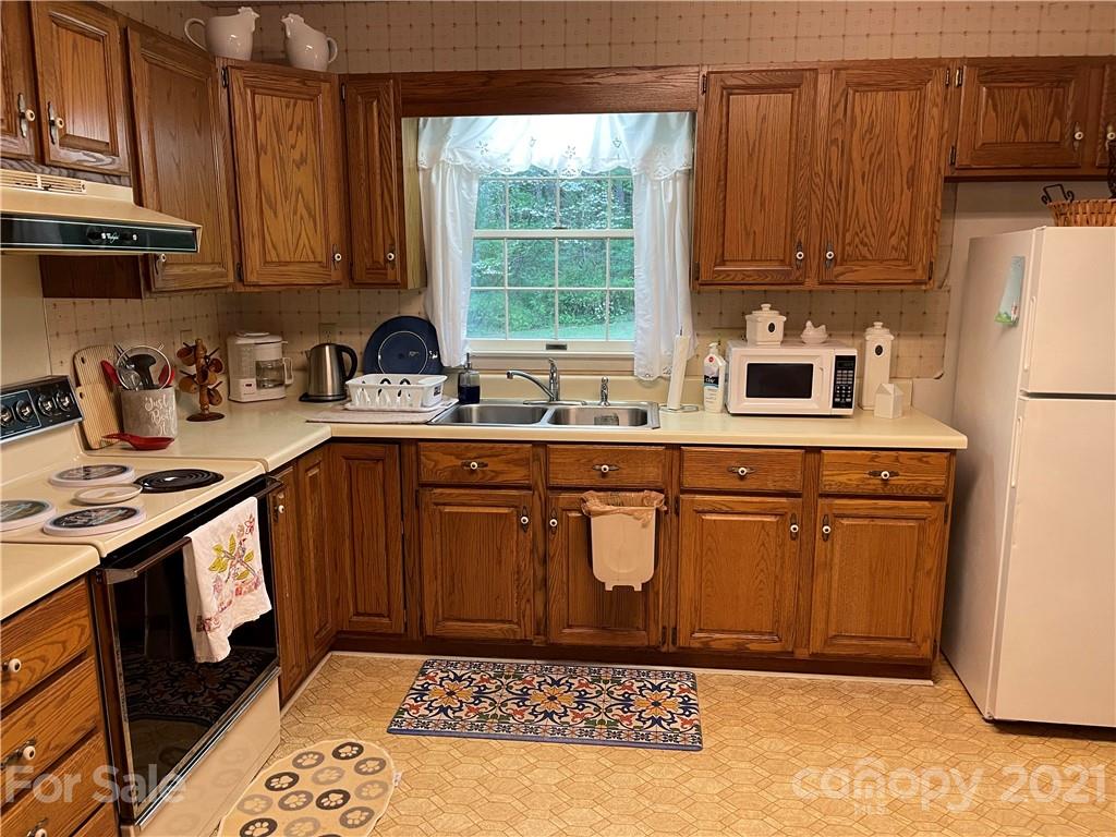 224 Lynch Street Rutherfordton, NC 28139 - Photo 5 of 23 a kitchen with kitchen island granite countertop a sink stove and refrigerator