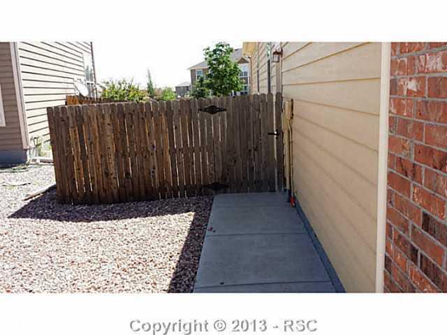 9373 St.George Road Peyton, CO 80831 - Photo 20 of 22 Fenced backyard with concrete walkway.