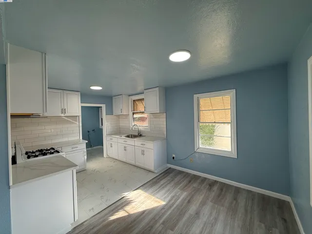 a kitchen with granite countertop white cabinets and white appliances