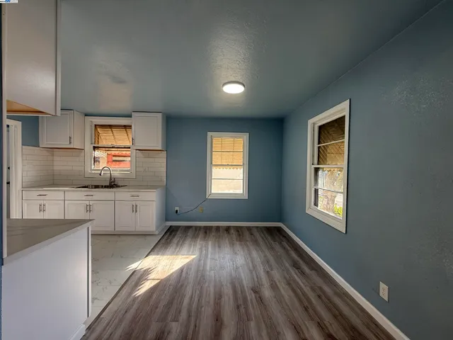 a kitchen with cabinets wooden floor and stainless steel appliances