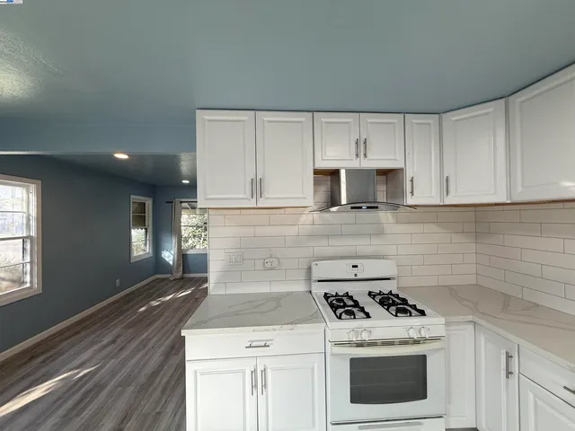 a kitchen with a stove top oven and cabinets