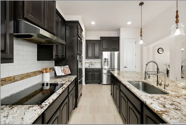a kitchen with stainless steel appliances granite countertop a sink stove and refrigerator