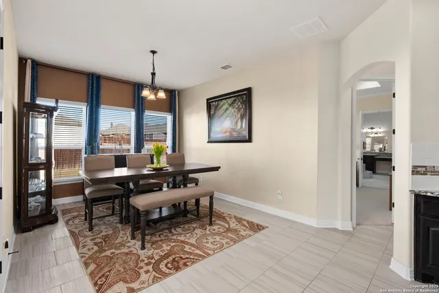 a living room with furniture a large window and a chandelier
