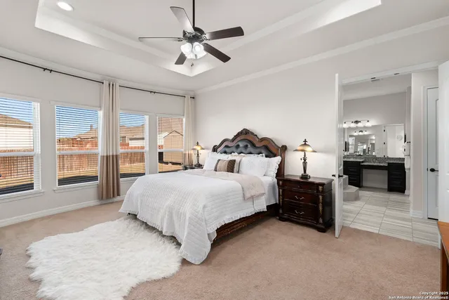 a spacious bedroom with a bed and ceiling fan