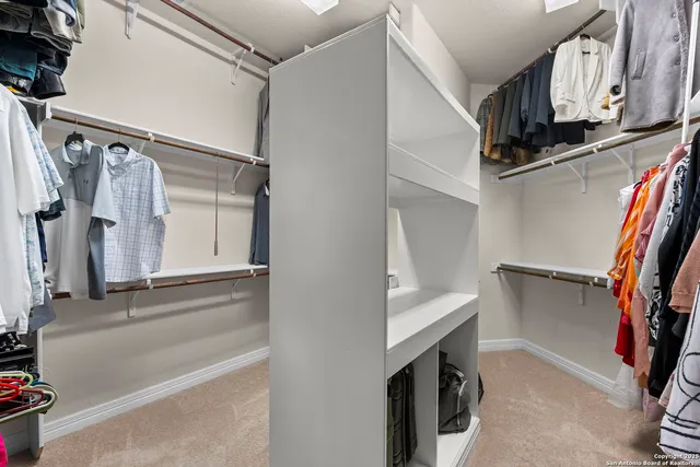 a view of walk in closet with clothes and shoes