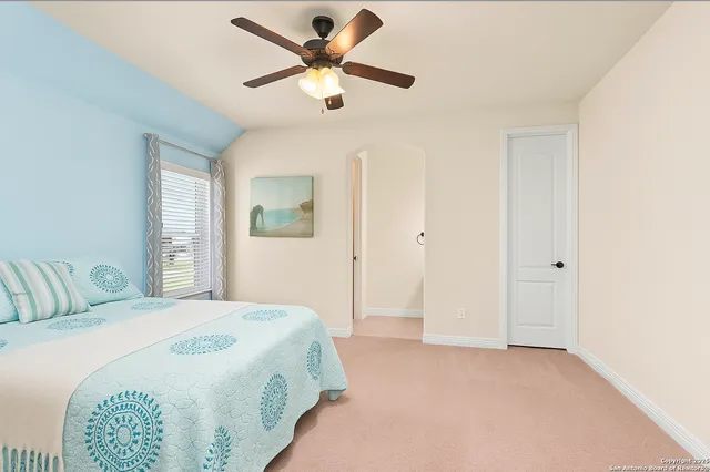a spacious bedroom with a bed and a chandelier