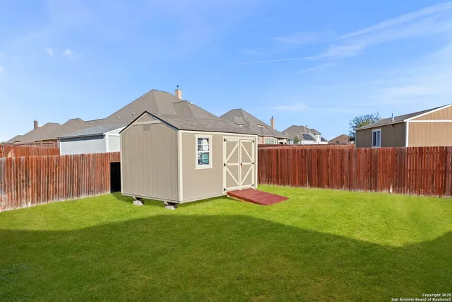 a view of a yard with wooden fence