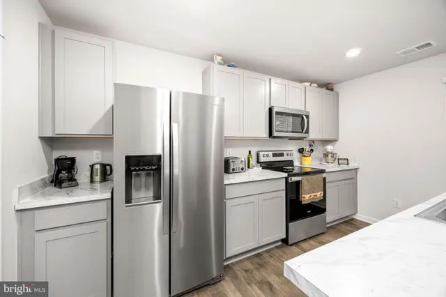 a kitchen with stainless steel appliances a stove microwave and sink
