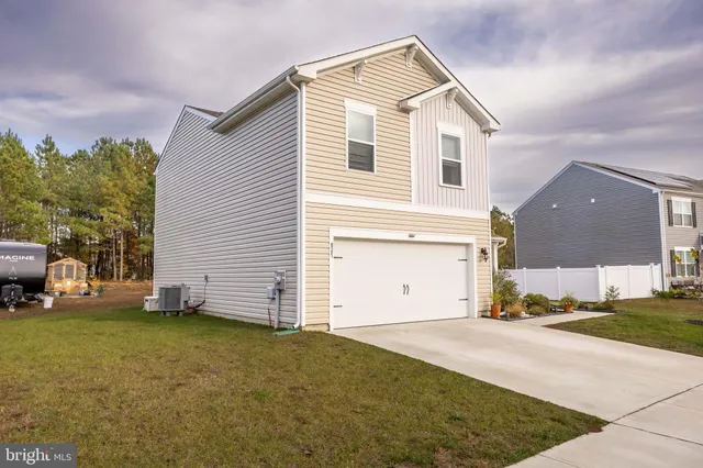 a view of a white house with a yard and garage