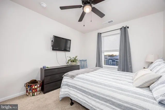 a spacious bedroom that has a bed and a chandelier