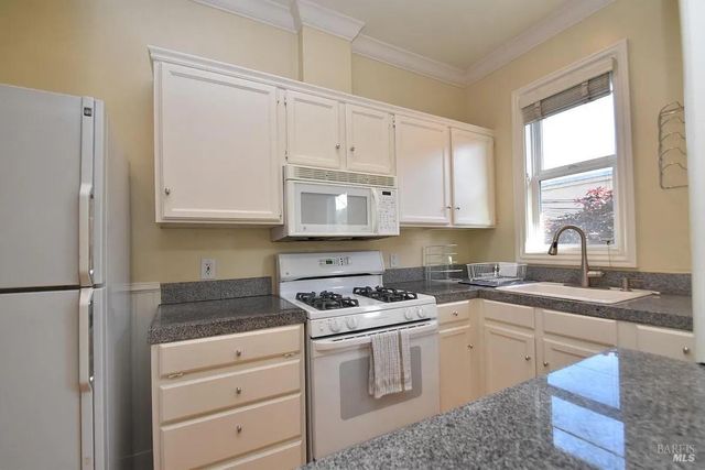 a kitchen with a table chairs refrigerator and window