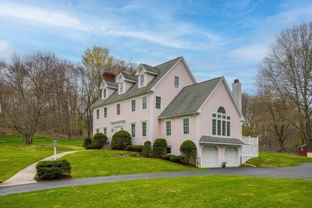 a view of a white house next to a yard with big trees