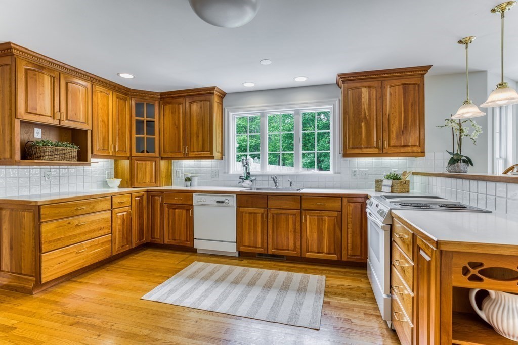 51 Glendale Road Boxford, MA 01921 - Photo 9 of 37 a kitchen with stainless steel appliances granite countertop wooden cabinets a stove top oven a sink and dishwasher with wooden floor