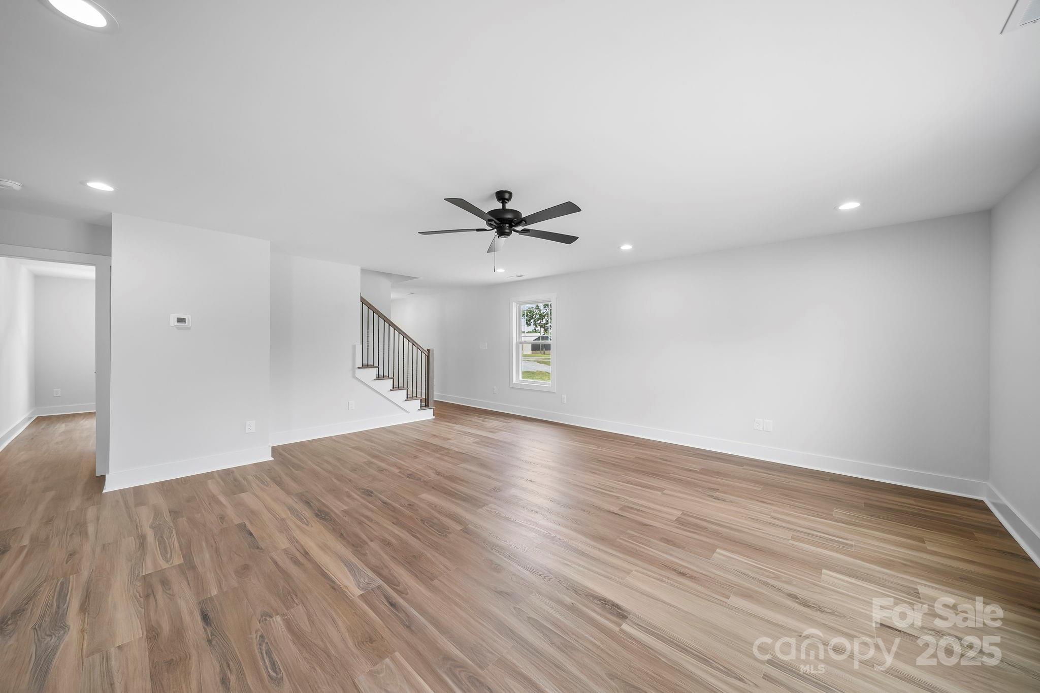 1312 Austin Chaney Road Wingate, NC 28174 - Photo 12 of 47 a view of empty room with wooden floor and ceiling fan