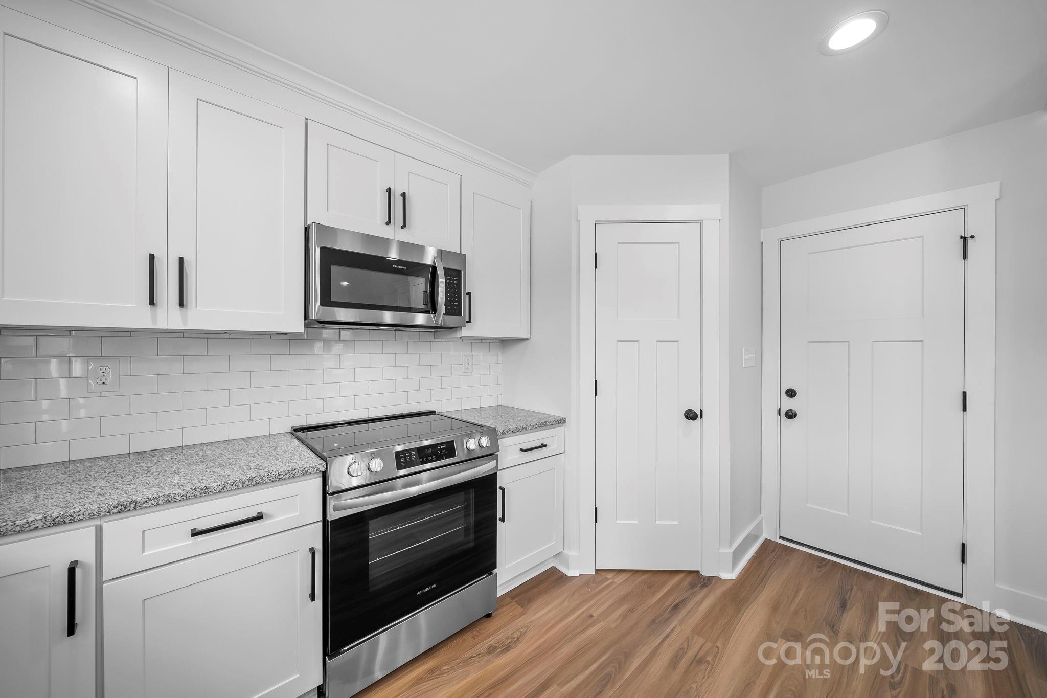 1312 Austin Chaney Road Wingate, NC 28174 - Photo 15 of 47 a kitchen with wooden floor and white stainless steel appliances