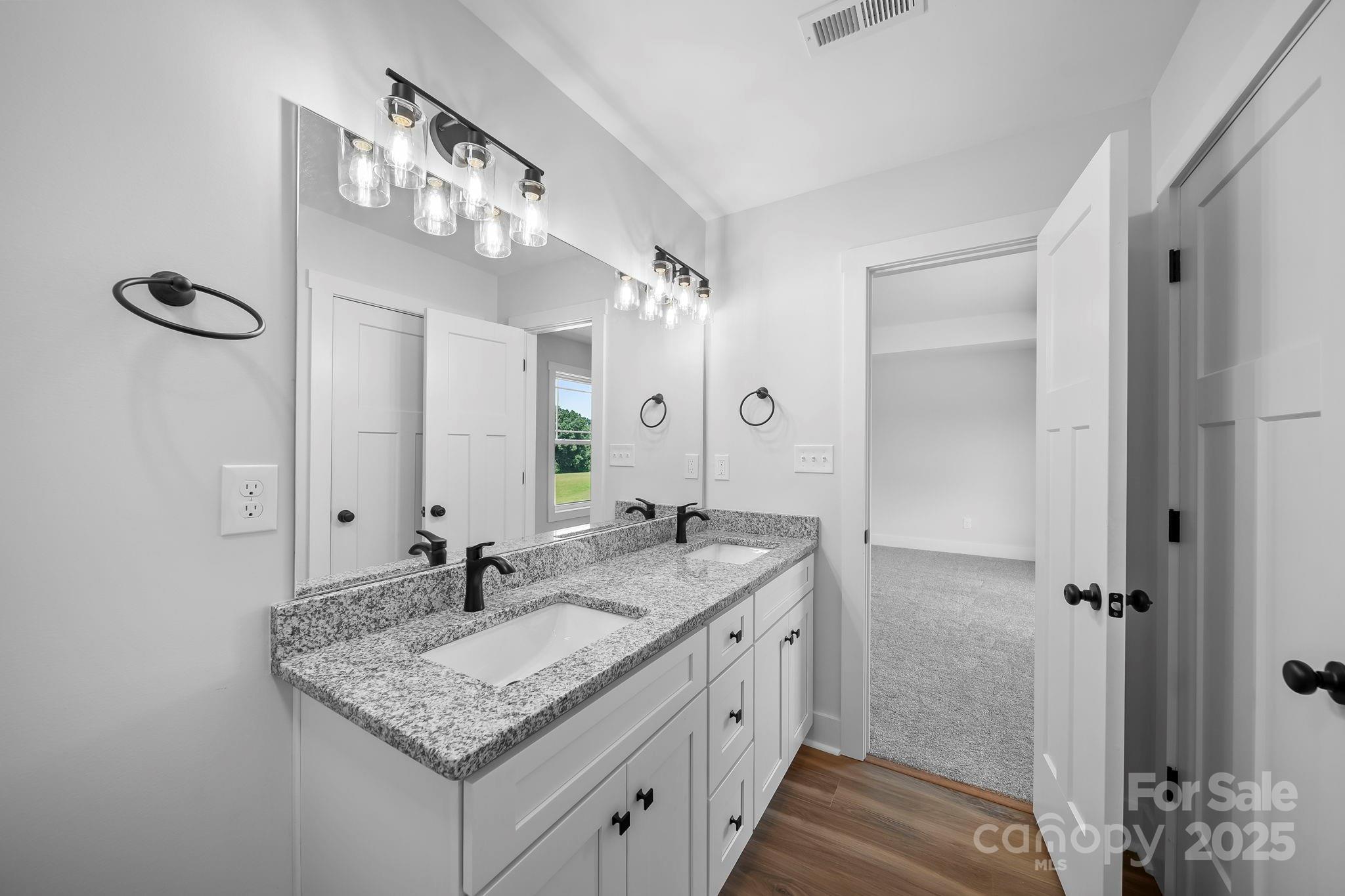 1312 Austin Chaney Road Wingate, NC 28174 - Photo 21 of 47 a bathroom with a granite countertop sink a large mirror and a shower