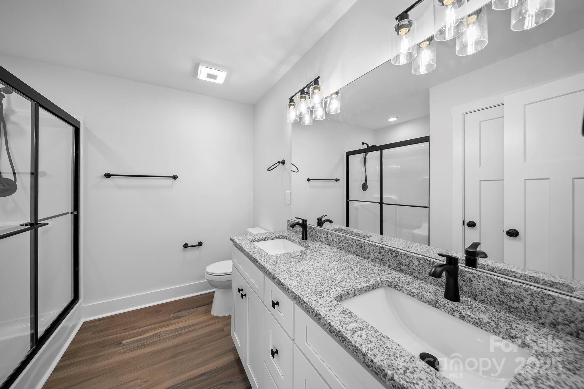 1312 Austin Chaney Road Wingate, NC 28174 - Photo 23 of 47 a bathroom with a granite countertop double vanity sink a mirror and shower