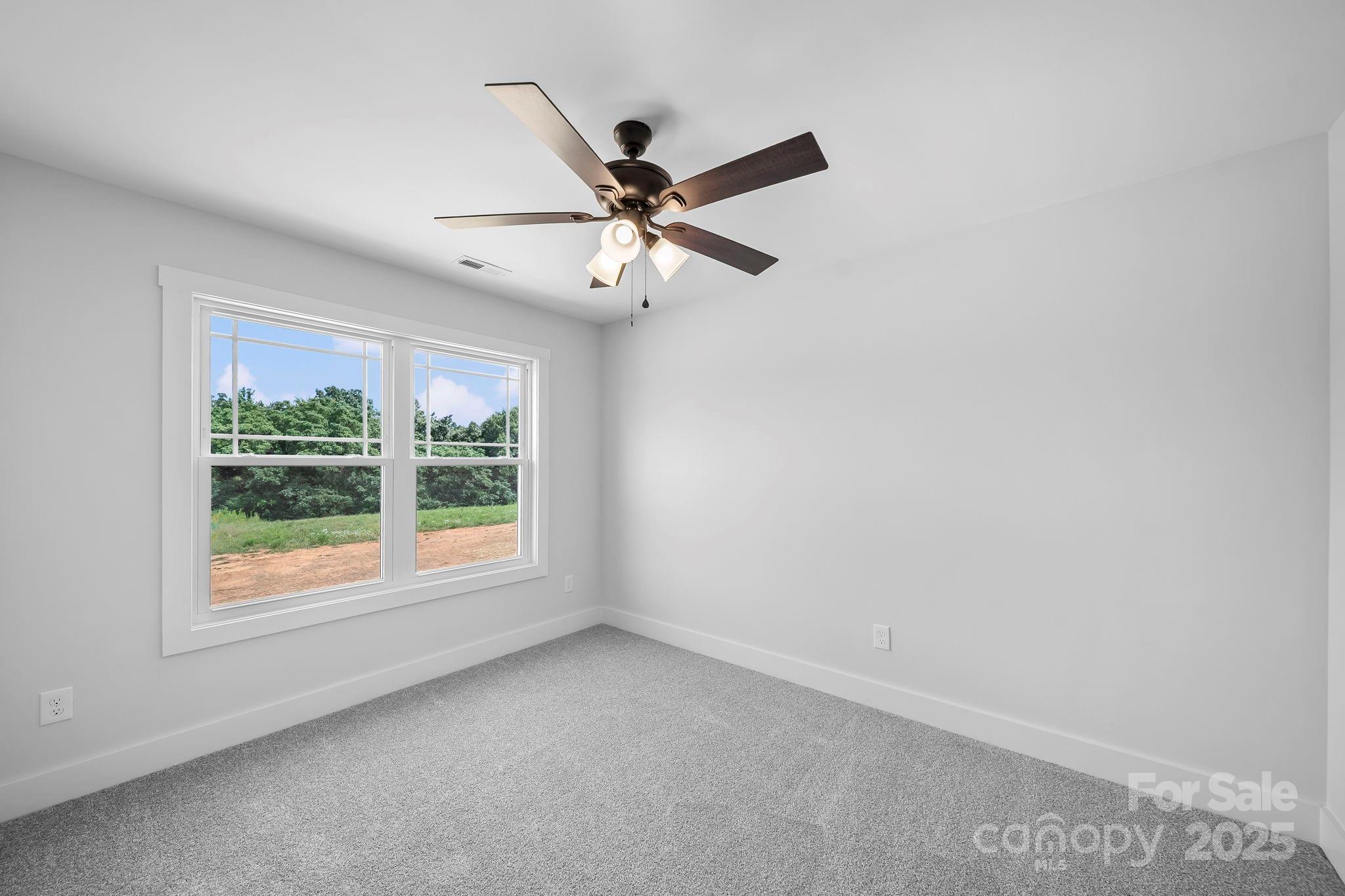 1312 Austin Chaney Road Wingate, NC 28174 - Photo 25 of 47 an empty room with a window and a fan