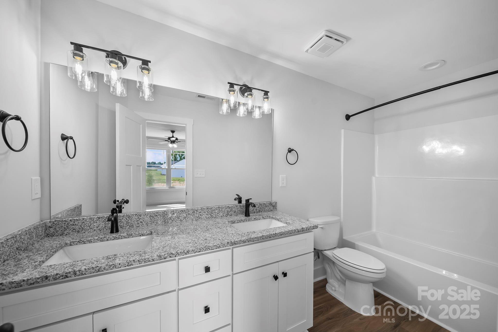 1312 Austin Chaney Road Wingate, NC 28174 - Photo 27 of 47 a bathroom with a granite countertop sink toilet and shower