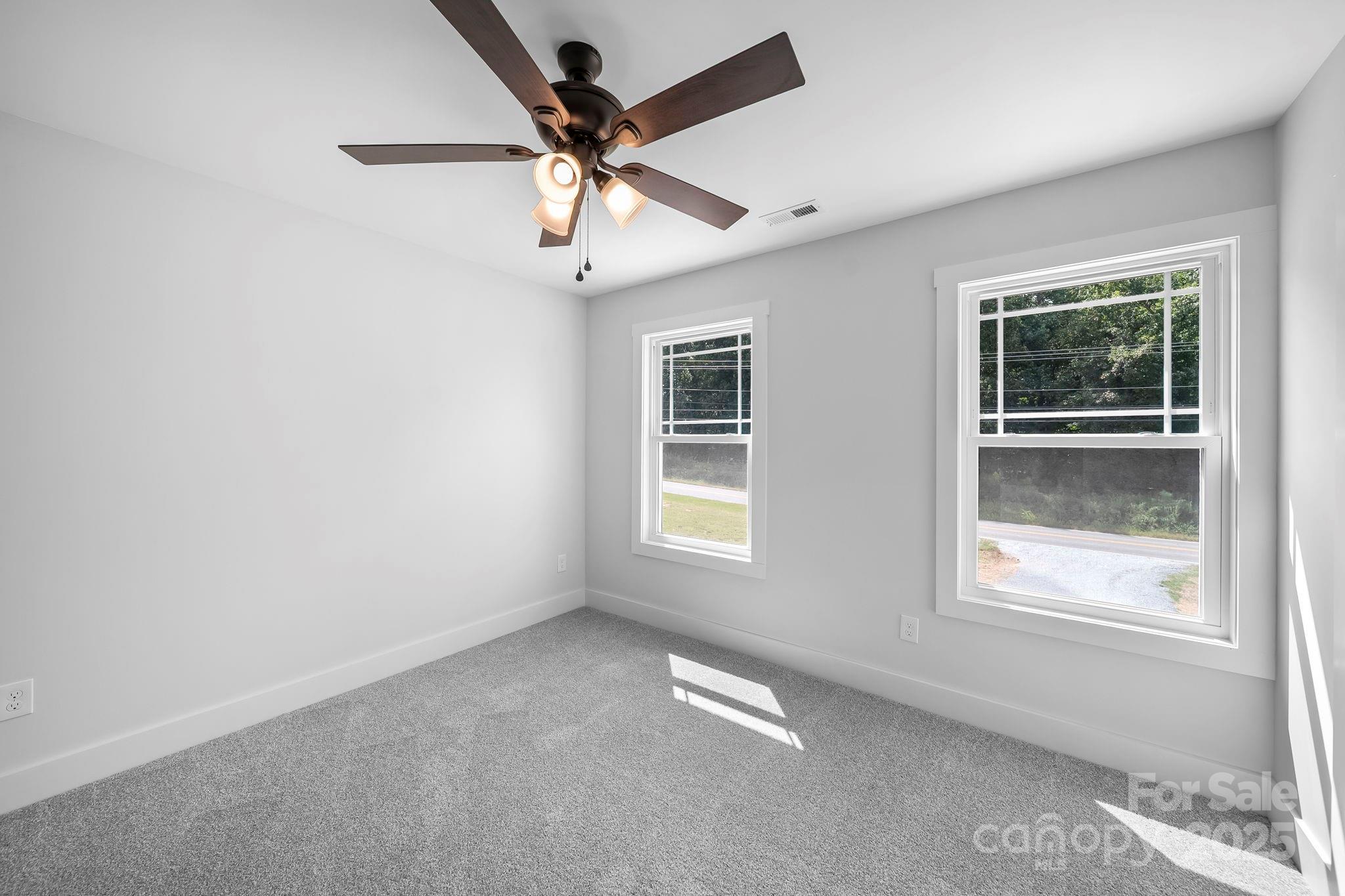 1312 Austin Chaney Road Wingate, NC 28174 - Photo 31 of 47 en empty room with windows and ceiling fan