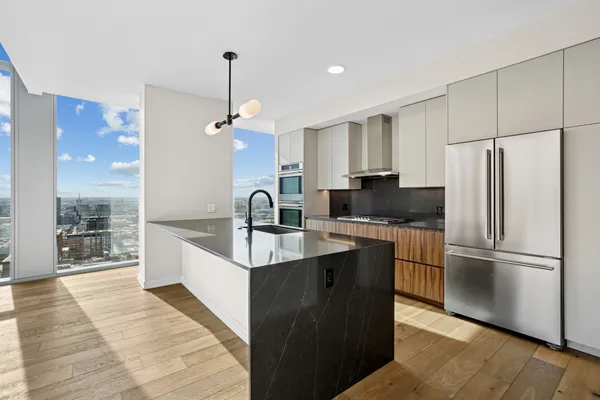 a kitchen with stainless steel appliances granite countertop a refrigerator a sink and a stove