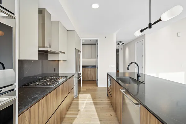 a kitchen with granite countertop a sink stove and cabinets