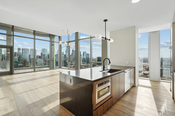 a large kitchen with kitchen island a large window a sink and stainless steel appliances