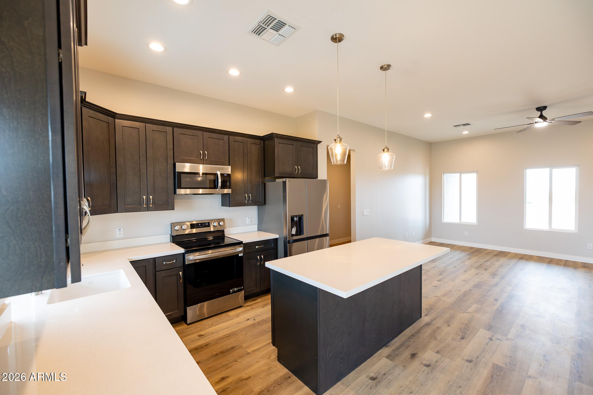 11459 East Adamsville Road Florence, AZ 85132 - Photo 14 of 63 a kitchen with kitchen island granite countertop a refrigerator and a sink